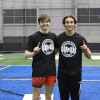 Students wearing championship shirts from a cornhole tournament for Monday